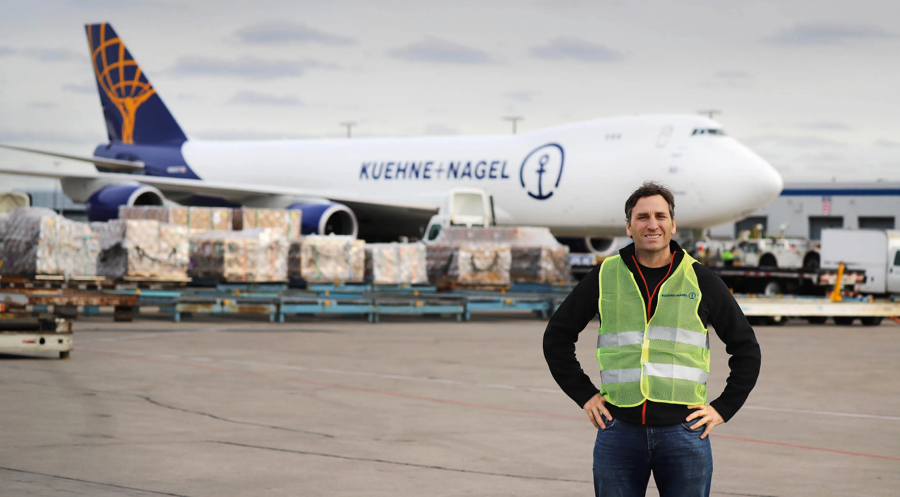 Kuehne+Nagel employee standing in front of a Kuehne+Nagel Boeing 747