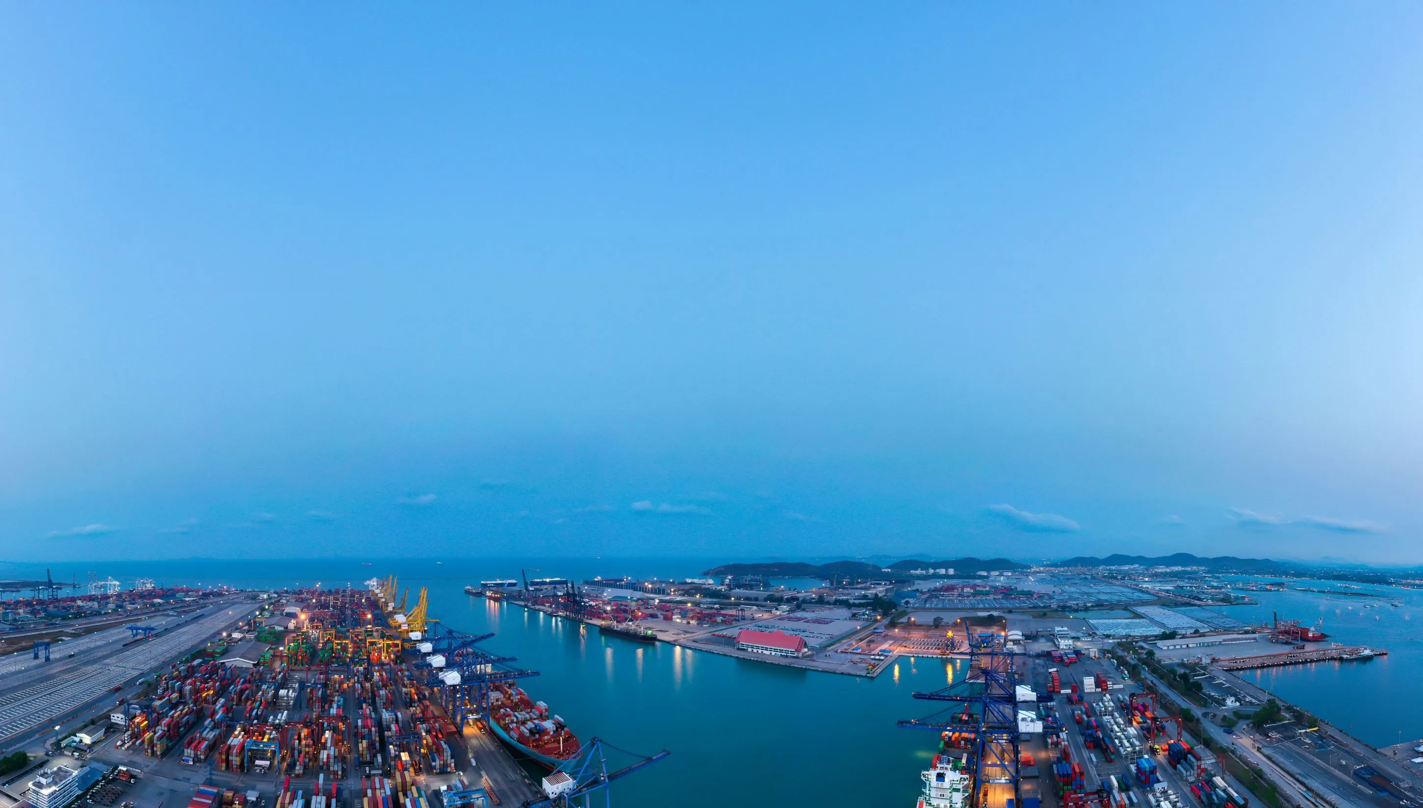 Harbour view at blue hour with containers, vessels and horizon