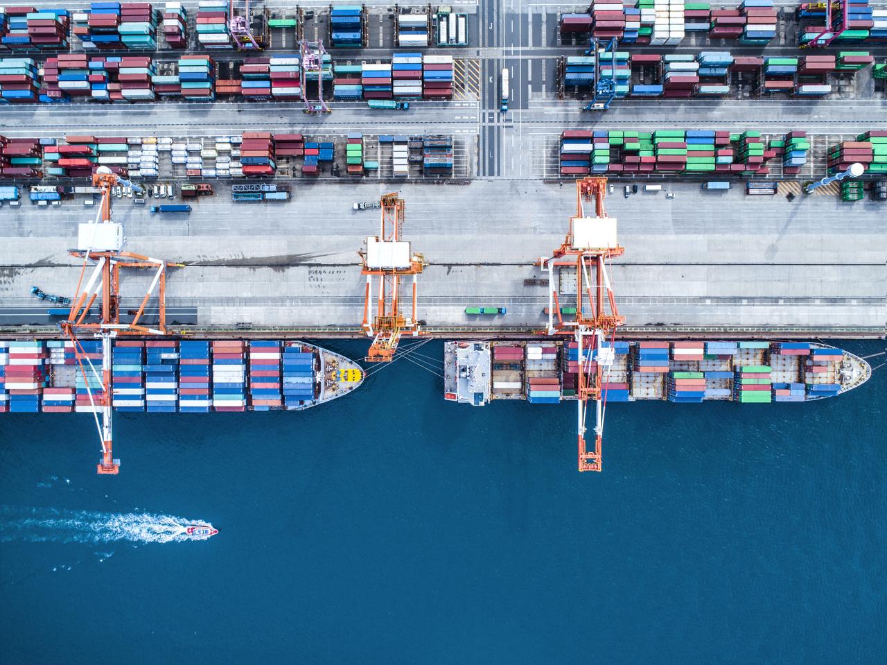 An areal view of two container ships docked in a container yard